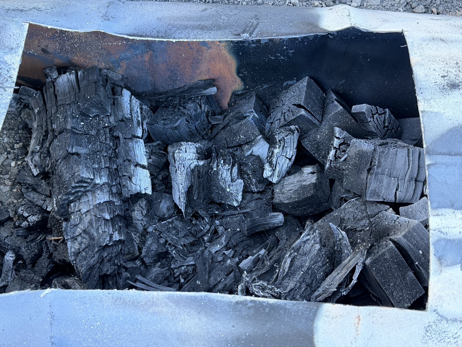 ドラム缶の窯の中でできあがった黒いスギ炭
